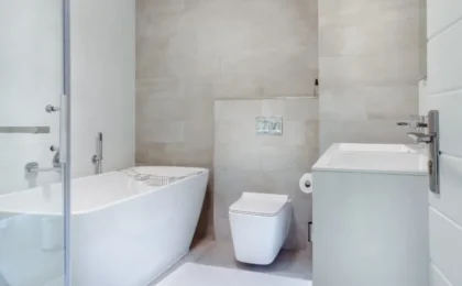Imagem de uma casa de banho moderna com banheira branca, exemplo de modernização das casas de banho com design elegante e funcional.