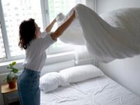 woman-making-bed-medium-shot