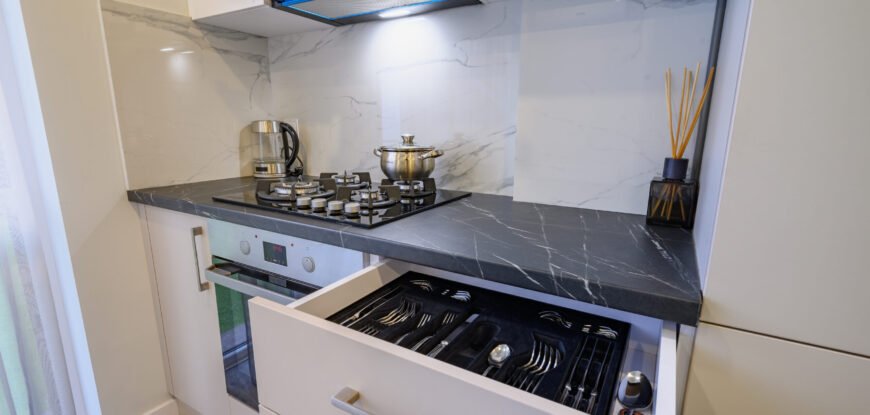 Luxury beige and cream kitchen interior details, some drawers retracted, high angle view